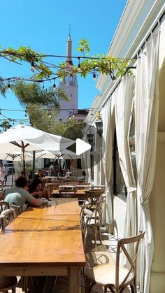 an outdoor dining area with tables and umbrellas