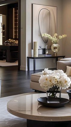 a living room filled with lots of furniture and flowers on top of a coffee table