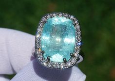 A Breathtakingly Striking HANDMADE 14k White Gold Ring with Beautiful Cushion Cut Paraiba Tourmaline in Green-Blue color! The GEM is 16.03 CT and measures 17.89x12.56x9.18 mm! This Stone will take your breath away, especially on the sunlight! You will want to look at this stone endlessly. The mounting is a masterpiece! HANDMADE 14K White Gold Diamond Mounting (tested), that was is custom made to Accommodate this Beauty of a Gem in a V-prongs setting! Super FINE Workmanship on the Diamond v-split Gia Certified Tourmaline Jewelry For Anniversary, Baguette Cut Ring, Ring Gold Diamond, Paraiba Tourmaline Ring, Paraiba Tourmaline, Custom Ring Designs, Tourmaline Ring, 14k White Gold Ring, Stone Cuts