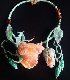 a necklace made with beads and flowers on a black background that says victoria zayatse