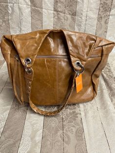 "X-Large size NWT smooth tan leather tote/handbag. Closure is a zipper. Use with built in straps or connect over the shoulder strap included. Interior lining is a cute cotton floral pattern. Great condition, 5 on level 1-5. Please look at pictures. Never used. Size is 17\"x 16\"x 10\" (Inches). Has been in storage with no light, no dust and temperature controlled." Brown Satchel Hobo Bag With Handle Drop, Light Brown Shoulder Bag With Zipper Closure, Brown Weekender Bag With Detachable Strap And Double Handle, Cognac Hobo Bag With Detachable Strap Tote, Cognac Hobo Bag With Adjustable Strap And Double Handle, Cognac Hobo Bag With Detachable Strap, Cognac Hobo Bag With Adjustable Double Handle, Light Brown Tote Satchel With Adjustable Strap, Casual Brown Shoulder Bag With Handle Drop