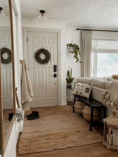 a bedroom with a bed, mirror and rug on the floor in front of it