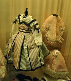 an assortment of dress and bonnets on display