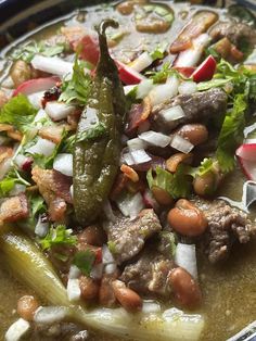 a bowl filled with meat and vegetables on top of a table