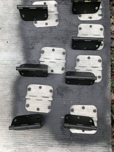 several black and white pieces of luggage sitting on top of a cement slab with grass in the background