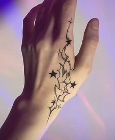 a person's hand with a tattoo on it and stars in the middle of their palm