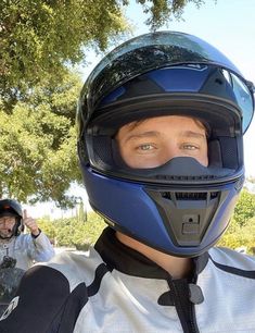 a man wearing a helmet and holding his fist up