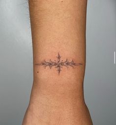 a small tattoo on the back of a woman's left leg, with an arrow