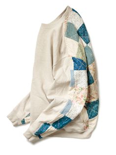 a white sweater with blue and green patchwork on it