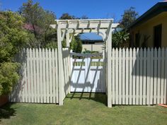 a white gate in the middle of a yard