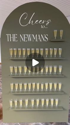 a sign that says cheers to the newnans with champagne glasses in front of it