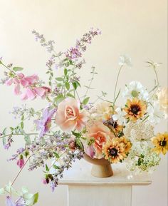 a vase filled with lots of different colored flowers