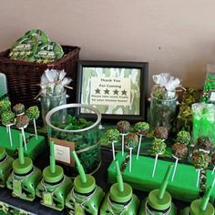 a table topped with lots of green candies and lollipops on sticks