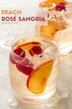 peach rose sangria with ice and raspberries in a glass on a white table