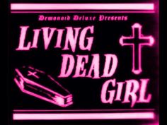 a neon sign that says living dead girl with a cross and book on the front