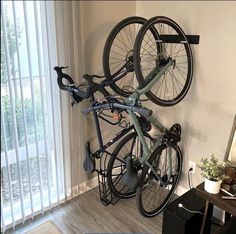 there is a bike mounted to the wall in this room with two bikes on it