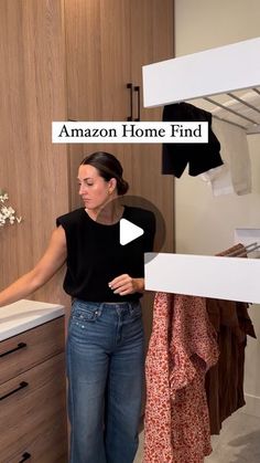 a woman standing in front of a closet with clothes hanging on the rack and an amazon home find sign above her