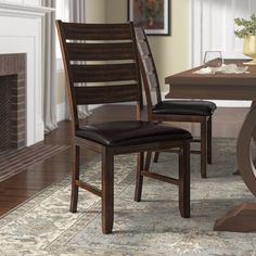 a dining room table with two chairs and a fire place