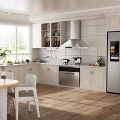 a modern kitchen with white cabinets and wood flooring is seen in this image from the front view