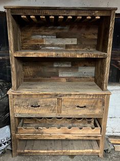 an old wooden cabinet with wine bottles in it's drawer and shelves on the side