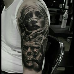 a man with a tattoo on his arm that has a woman and two skulls in it