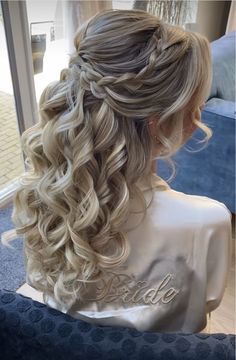 the back of a woman's head with long blonde hair in a half - up braid