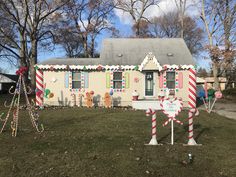 a house decorated for christmas with candy canes and decorations on the front lawn,