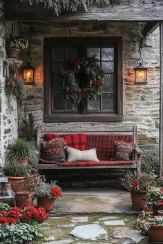 a red and white couch sitting on top of a stone patio next to potted plants