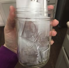 a person holding a mason jar filled with ice