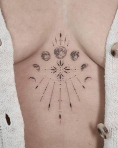 a woman's back with an arrow and planets tattoo on her left side ribcage