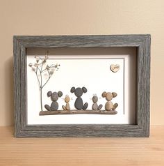 three stuffed mouses are sitting on a shelf next to a framed photo with flowers