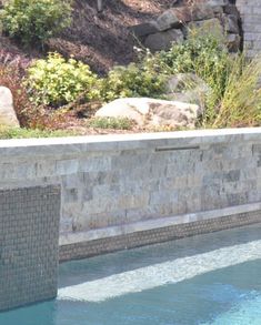 a man sitting on the edge of a swimming pool