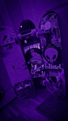 the skateboard is lit up with purple light and has skulls all over it's sides