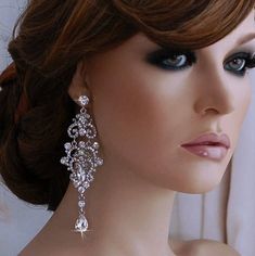 a mannequin head with earrings on it's face, wearing a white dress