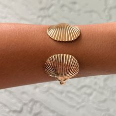 Elevate your summer style with our adjustable Seashell Open Cuff Bracelet. Made from 18k gold plated over stainless steel, this bracelet is waterproof, tarnish free, and hypoallergenic. Perfect for any occasion, it brings a touch of elegance and beachy charm to your look. A summer must-have! DETAILS: -Adjustable -Seashell Measurements: 2.8 cm. approx. -Metal: 18k Gold Plated over Stainless Steel -Hypoallergenic, lead & nickel free -Handmade -100% US sourced -Product type: Bracelet -Avoid contact with anything containing derivatives of alcohol -Some pictures feature additional products that are sold separately. Please note: Due to the one-of-a-kind nature of the medium, exact colors and patterns may vary slightly from the image shown Bracelet Seashell, Sea Shell Bracelet, Trendy Bracelet, Open Cuff Bracelet, Trendy Bracelets, Seashell Jewelry, Hand Bracelet, Shell Bracelet, Arm Cuff