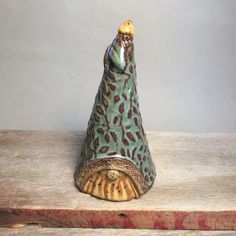 a ceramic bird figurine sitting on top of a wooden table