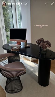 a desk with a computer on it in front of a window