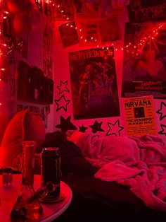 a bedroom with red lights and posters on the wall