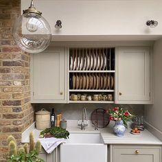 a kitchen filled with lots of counter space and dishes on top of the cupboards