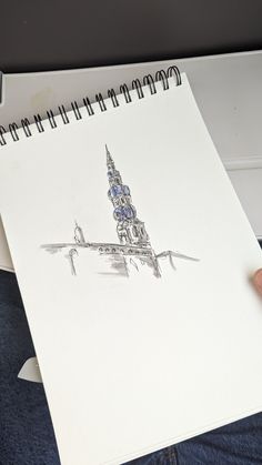 a drawing of a building on top of a white paper with a pen in it