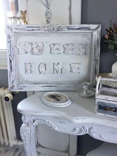 an old white table with a sign on it that says sweet home next to a radiator