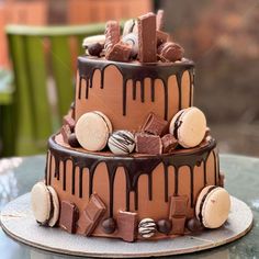 a three layer chocolate cake with lots of candy toppings on the top and bottom