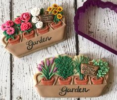 two cookies shaped like flower pots with plants in them and the words garden written on one cookie