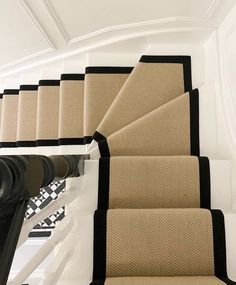 a set of stairs with black and beige carpet