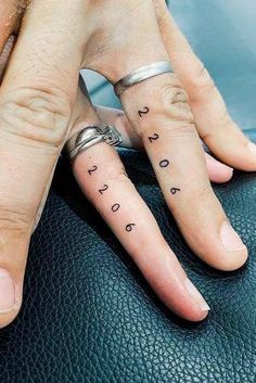 two people with matching tattoos on their fingers