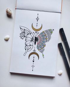 a card with an intricate design on it next to some pencils and seashells