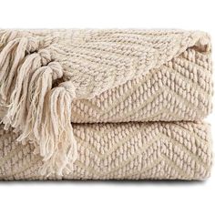 a blanket with fringes is folded on top of each other