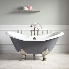 an old fashioned claw foot bathtub in a bathroom with white walls and flooring