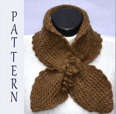 a brown knitted scarf with a bow on the front and bottom, sitting on top of a mannequin