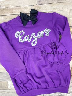 "Custom embroidered sweatshirt, girls embroidered sweatshirt, girls personalized sweatshirt,custom team sweatshirt, football sweatshirt Hi, first of all welcome to our shop!❤️ This listing is a girls personalized sweatshirt. 💥💥due to supply and demand the color availability may change! 💥💥please just reach out if you want to customize! This could be done on so many different options such as different style sweatshirts, tshirts, tank tops, dresses, women's sizes as well as I have a non script version for a little boy!  ⚡️These are custom made and hand trimmed, so I like to tell people the shorter team \"name\" you choose the bigger the word will look for instance razorbacks or Clemson would have much smaller letters than tigers and razors :) you can also completely change the design on t Crew Neck Sweatshirt With Team Name For Cheerleading, Purple Crew Neck T-shirt With Team Name, Customizable Cotton Sweatshirt For Cheerleading, Crew Neck T-shirt With Name Print For Cheerleading, Name Print Crew Neck T-shirt For Cheerleading, Team Sweatshirts, Football Sweatshirt, Small Letters, Girl Sweatshirts